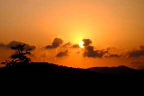 黄昏躲在乌云后面的夕阳图片